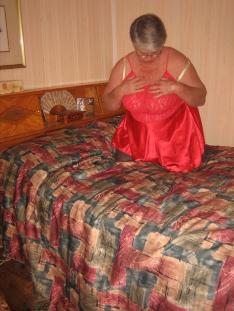 Fat granny Girdle Goddess pets her femininity after stripping to hosiery on her bed