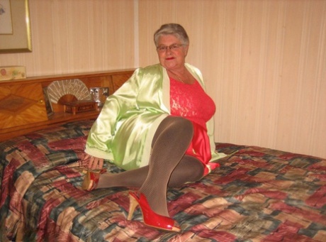 Fat granny Girdle Goddess pets her femininity after stripping to hosiery on her bed