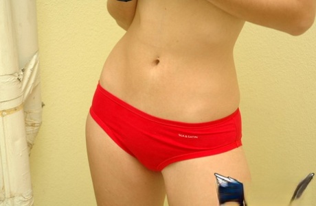 Young cheerleader Amy lifts her uniform to tease with alluring panties & underboob