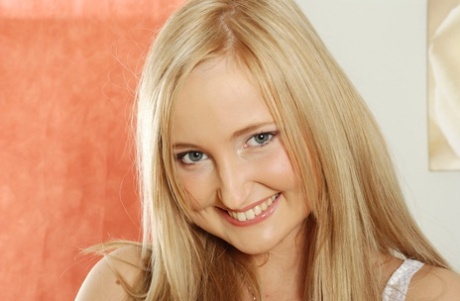 Smiling blonde girl frees her camel toe femininity from short denim shorts