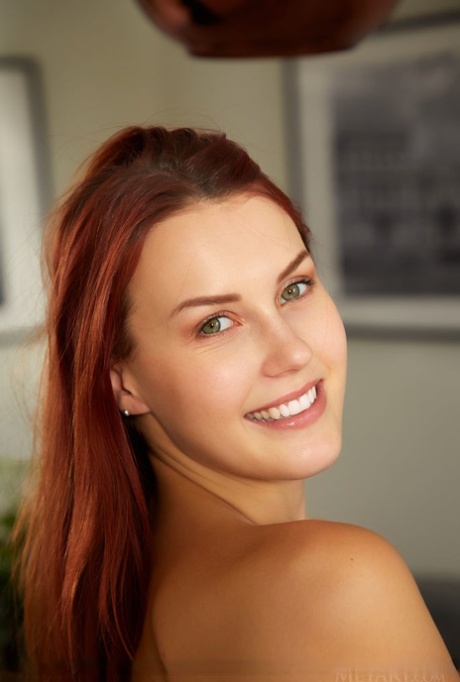 Alluring redhead Charlie Red bares her phat curves and bald slit in a dining room