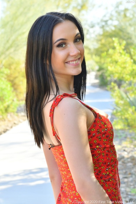 Cute brunette girl Jasmin shows her attractive figure before toying herself indoors