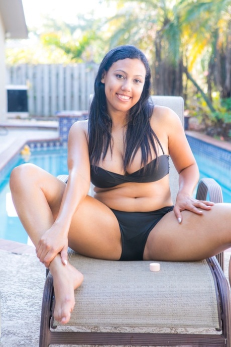 Chubby black authentic removes her bikini to pose artistic on chair by a pool