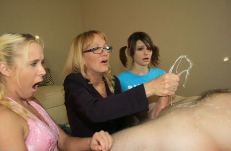 Mature blonde in glasses teaching her young adult friends how to stroke a big manhood
