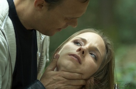 Skinny blonde girl is ties to a freshly cut tree in the forest