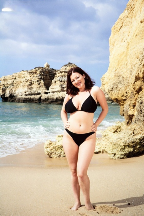 Brunette MATURE WOMAN Lorna Morgan releases her nice melons from bikini on a beach