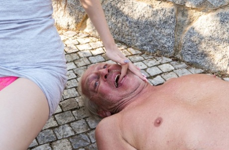 Skinny young adult Nela Decker gives a kinky grandpa a CFNM hanjob outdoors