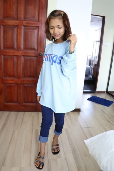 Pretty Asian girl Emelyn shows off her petite body while undressing for intimacy