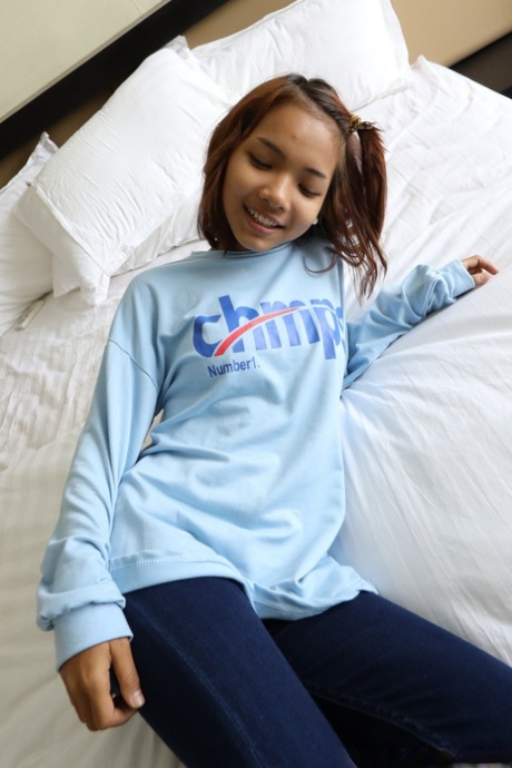 Pretty Asian girl Emelyn shows off her petite body while undressing for intimacy