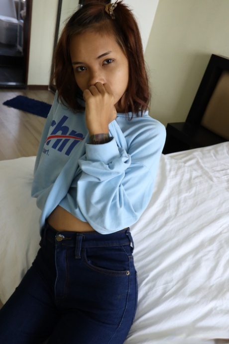 Pretty Asian girl Emelyn shows off her petite body while undressing for intimacy