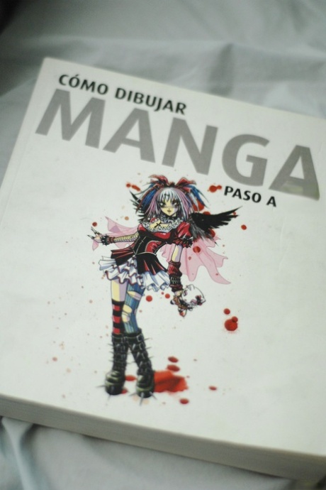 Thin young adult Estelle K gets natural in fingerless gloves while reading a Manga book