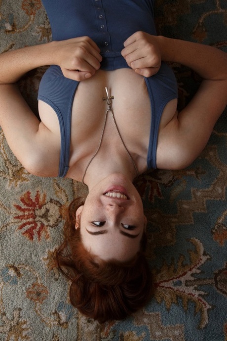 Alluring redhead Sabrina Lynn teases with her attractive curves in a bodysuit & boots