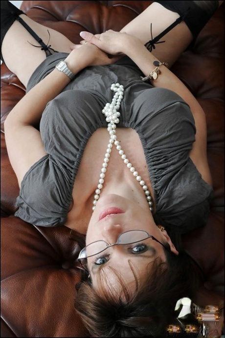 Lustful mature lady in stockings fingering her pink twat