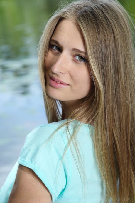 Cute blonde Sheela A undressing by the lake to show nice big breasts & attractive cunt