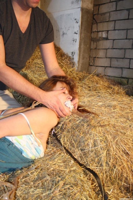 Naughty pantiless young adult Anouk bound with rope & gagged with tape in the barn