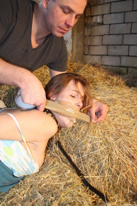 Naughty pantiless young adult Anouk bound with rope & gagged with tape in the barn