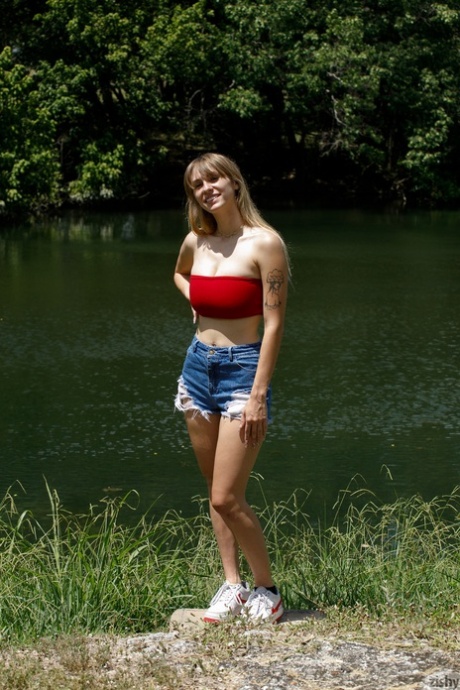 Charming babe in booty shorts Angel Youngs shows off her juicy breasts outdoors