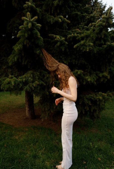 Beautiful braless authentic babe with big breasts posing in her white dress outside