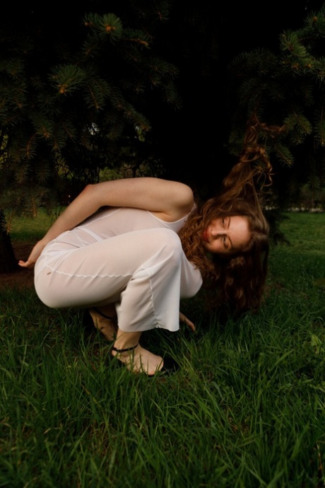 Beautiful braless authentic babe with big breasts posing in her white dress outside