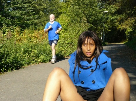 Ebony chick fingers her femininity on roadway while a jogger passes by