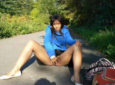 Ebony chick fingers her femininity on roadway while a jogger passes by