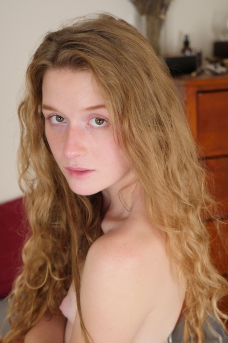 Pale redhead Karina Pontiac slips off her robe to model totally natural on bed
