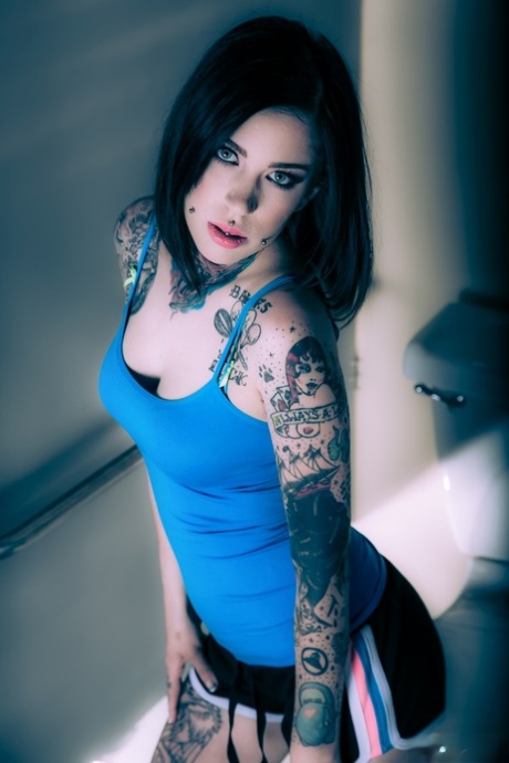 Brunette tattoo model revealing tiny breasts and tight curves before masturbating