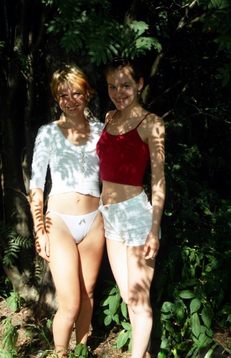 Smiles besties flash attractive curves outdoors and play natural in the shower together