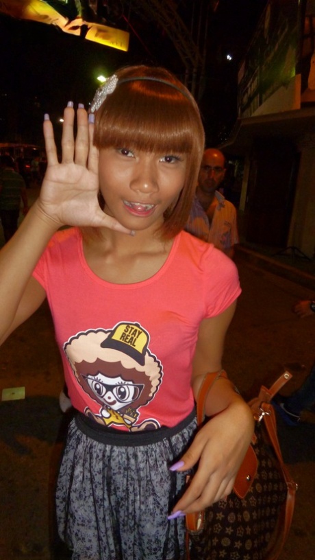 Red-haired Asian ladyboy lifts dress up to flash manhood in public place