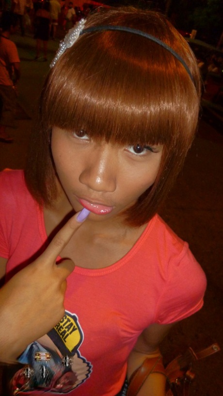 Red-haired Asian ladyboy lifts dress up to flash manhood in public place