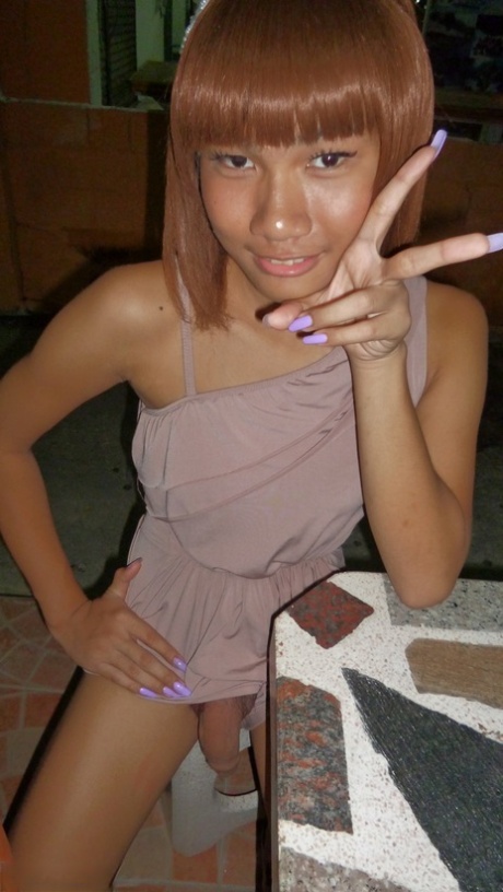 Red-haired Asian ladyboy lifts dress up to flash manhood in public place