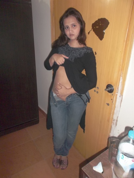 Attractive Indian model in tight jeans posing seductively in alluring lace bra