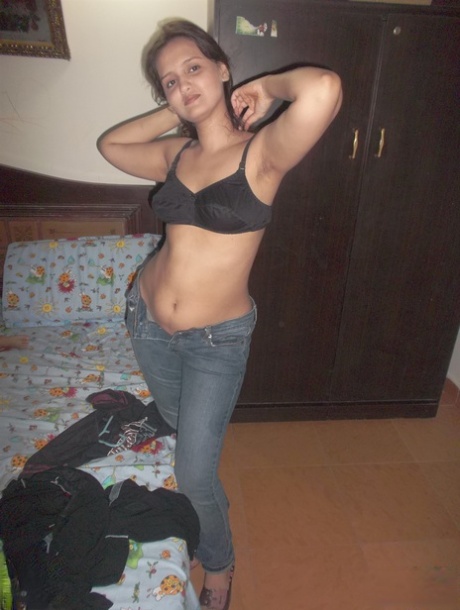 Attractive Indian model in tight jeans posing seductively in alluring lace bra