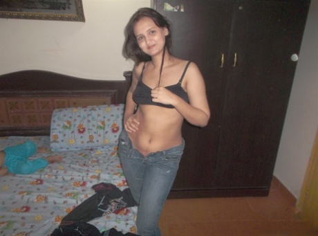 Attractive Indian model in tight jeans posing seductively in alluring lace bra