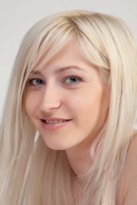 Sweet blonde young adult Janelle B teasingly exposes her smooth vagina