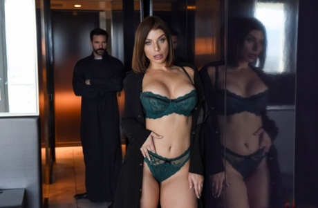 Brunette chick covers up her natural breasts in front of a Priest