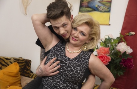 Chunky mature broad and her boy toy make out before fucking on couch