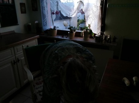 Horny granny Caro sticks a banana inside her natural femininity on kitchen chair