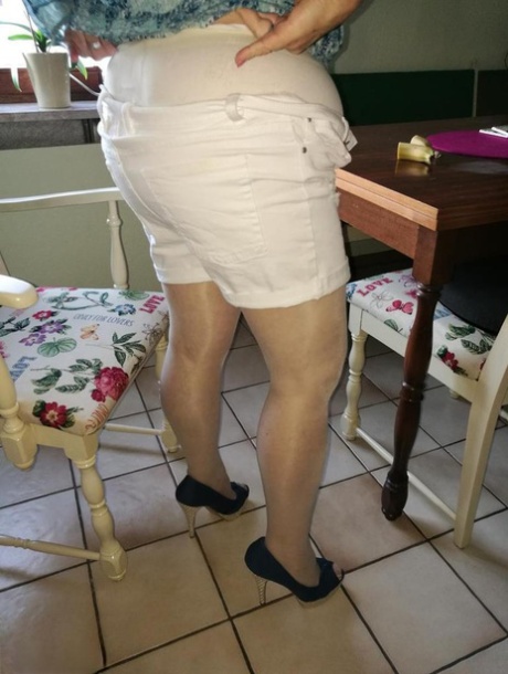 Horny granny Caro sticks a banana inside her natural femininity on kitchen chair