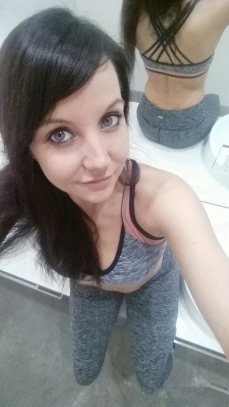 Slim young adult Andi Land takes candid artistic and clothed selfies while at home