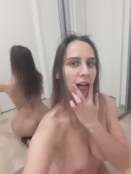 Naughty authentic babe poses natural in the mirror and shows her juicy breasts