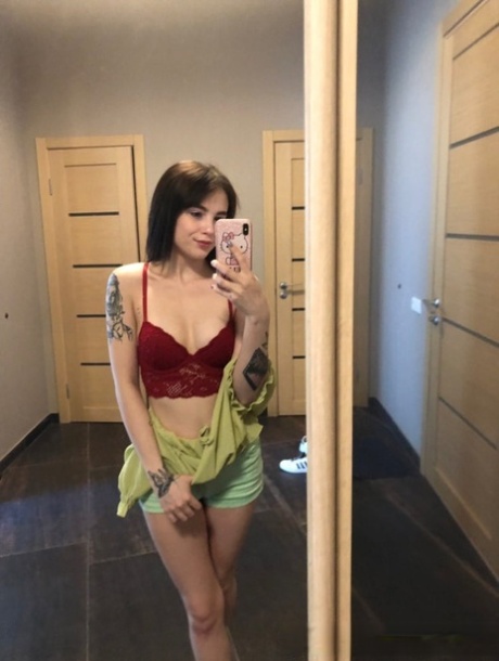 Slender amateur brunette strips and poses naked in front of the mirror