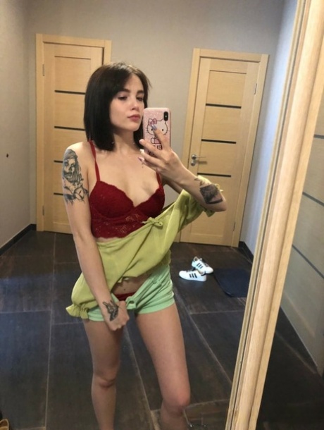 Slender amateur brunette strips and poses naked in front of the mirror