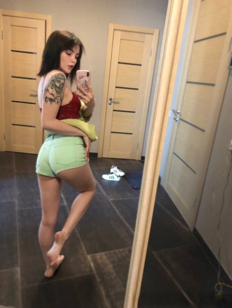 Slender amateur brunette strips and poses naked in front of the mirror