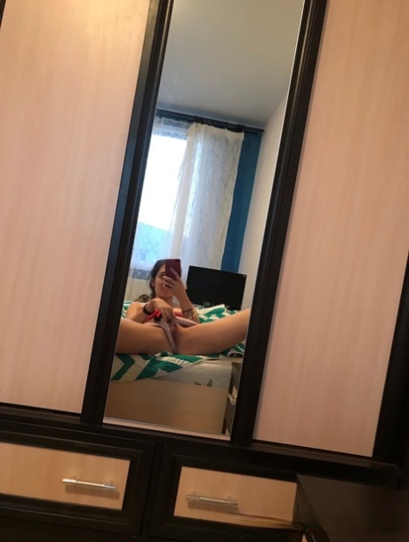 Amateur honey with small tits posing naked in front of a mirror