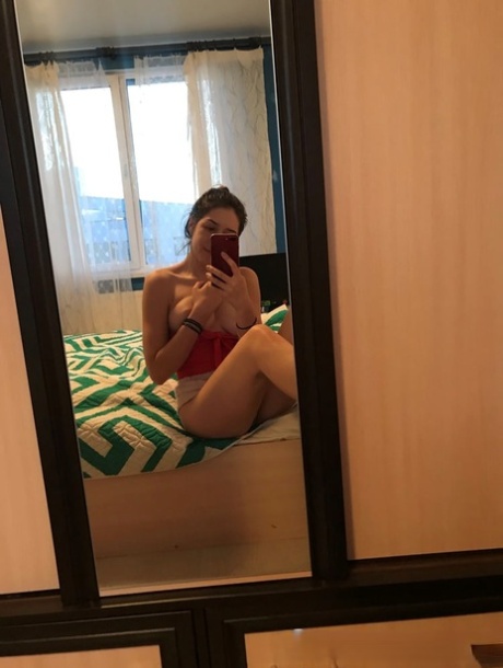 Amateur honey with small tits posing naked in front of a mirror