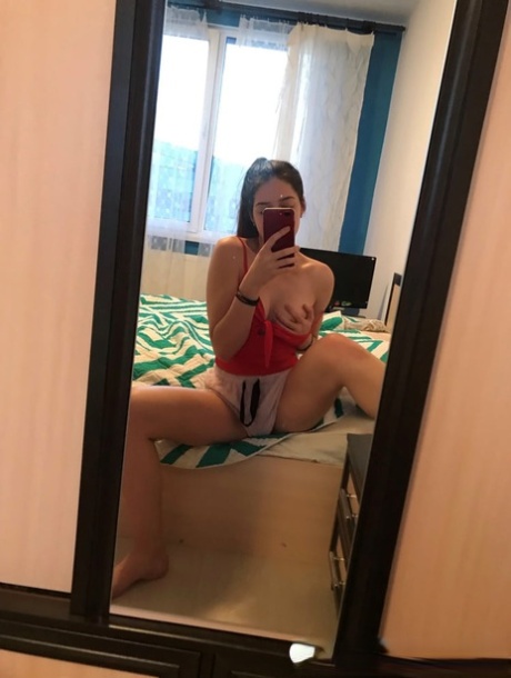 Amateur honey with small tits posing naked in front of a mirror