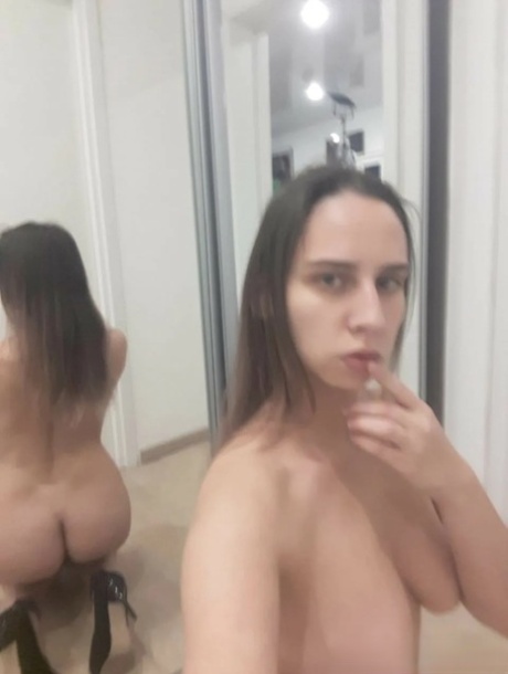Foxy brunette teases with her big tits and hot ass in the mirror