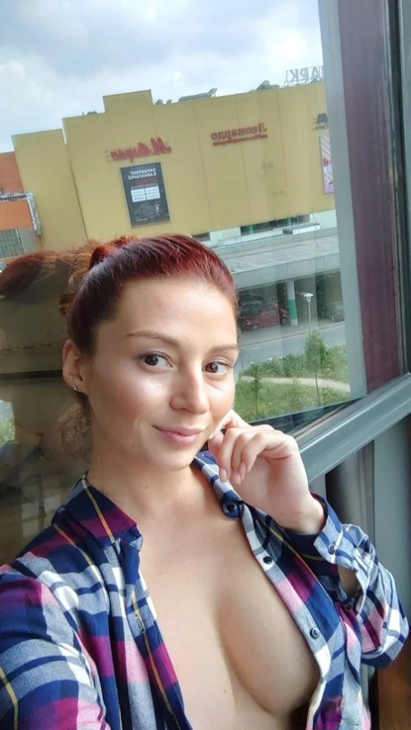 Gorgeous redhead shows off her big tits & her tattoos while taking nudes